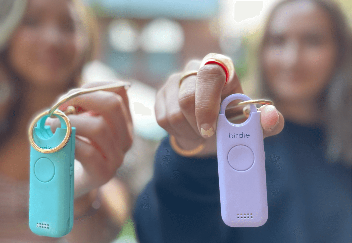 Two people holding personal safety alarms called 'birdie.'
