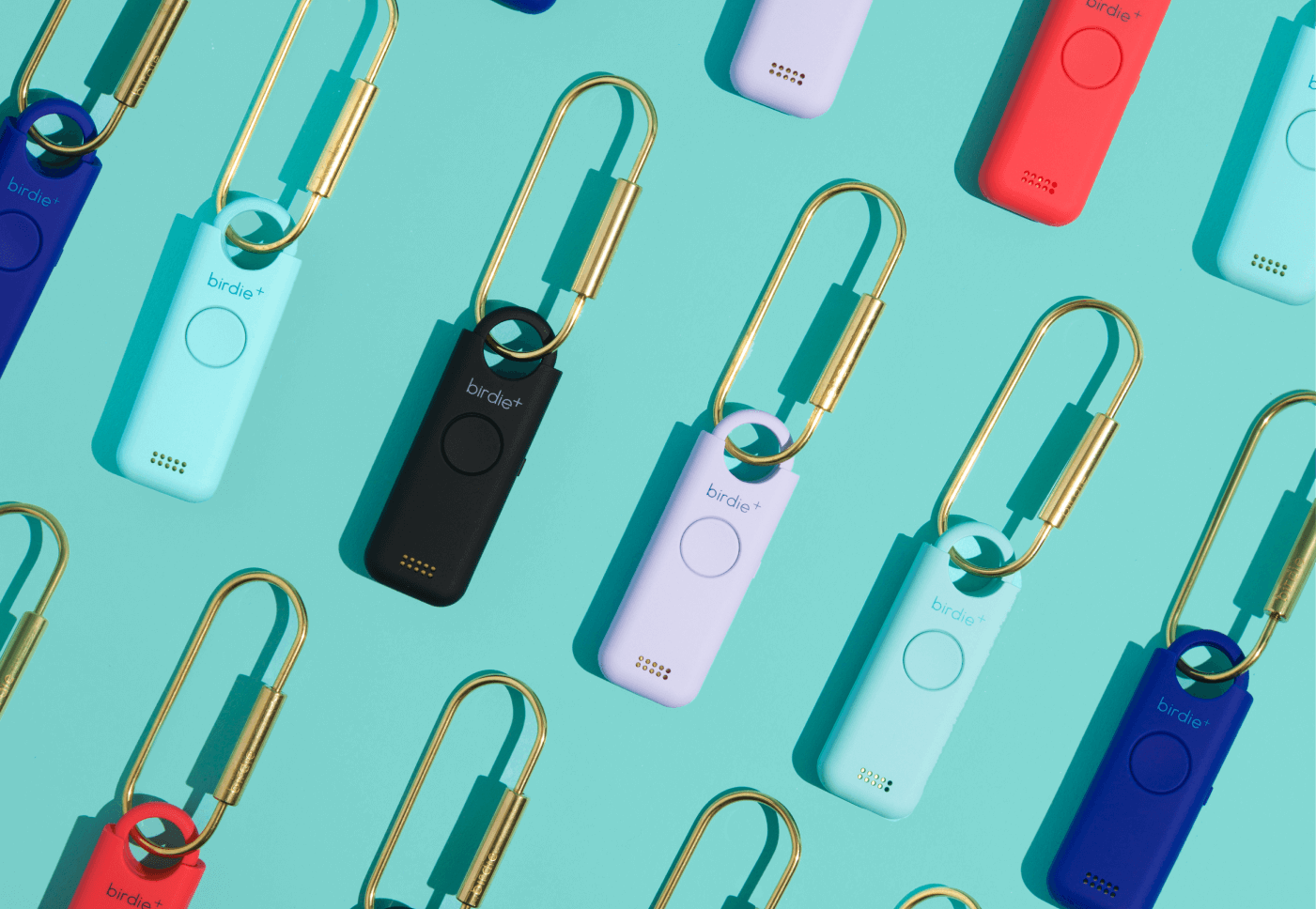 Colorful personal safety alarms with keychains on a teal background.